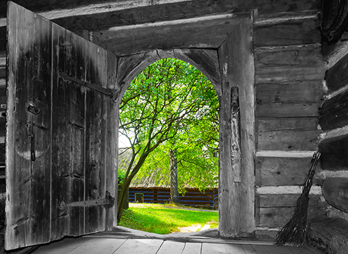 Opened door of the old rural house to a bright, sunny day.