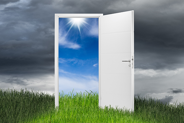 white open door on green grass landscape in front of blue cloudy sky change wide panorama concept background